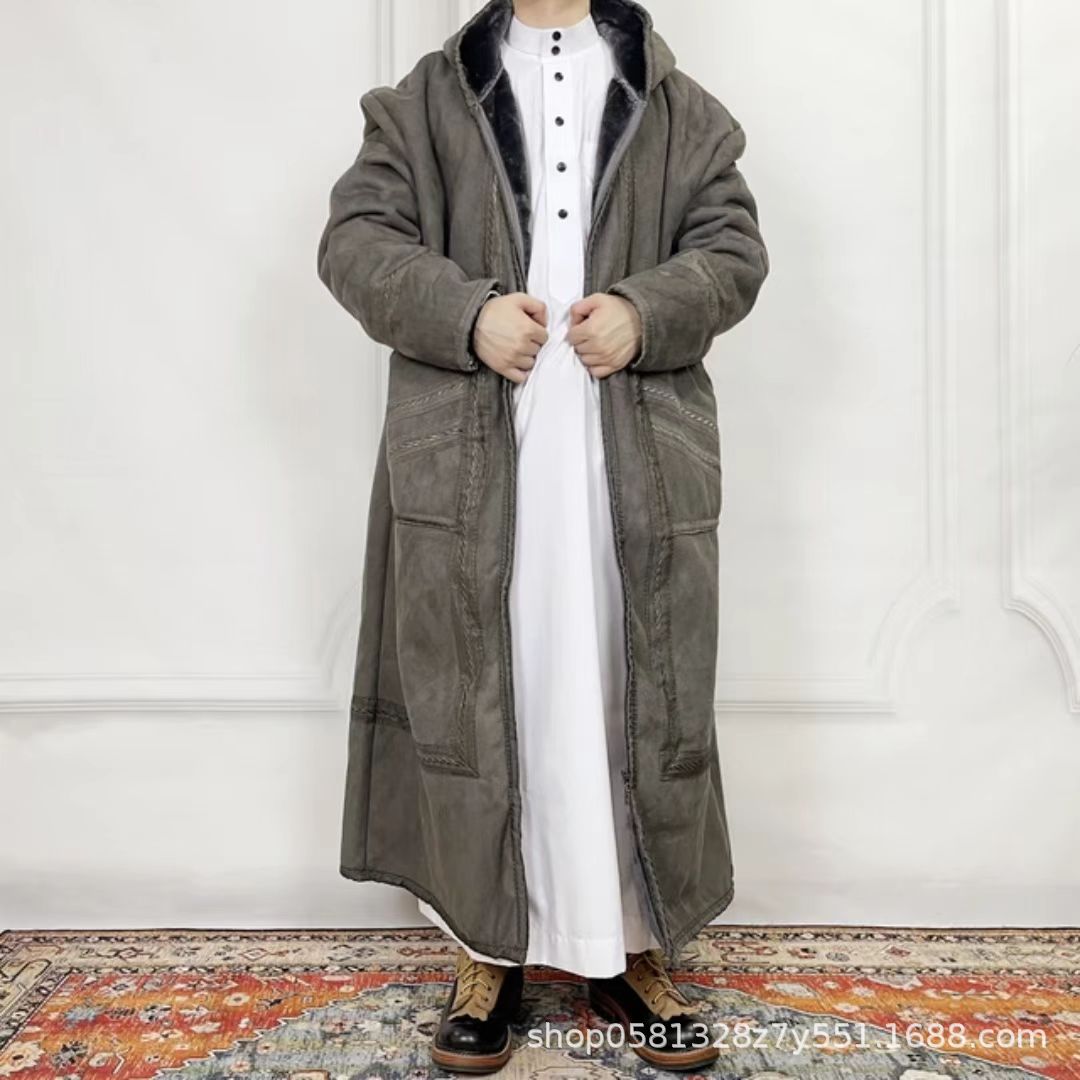 Person wearing a long dark coat over a white outfit on a white background