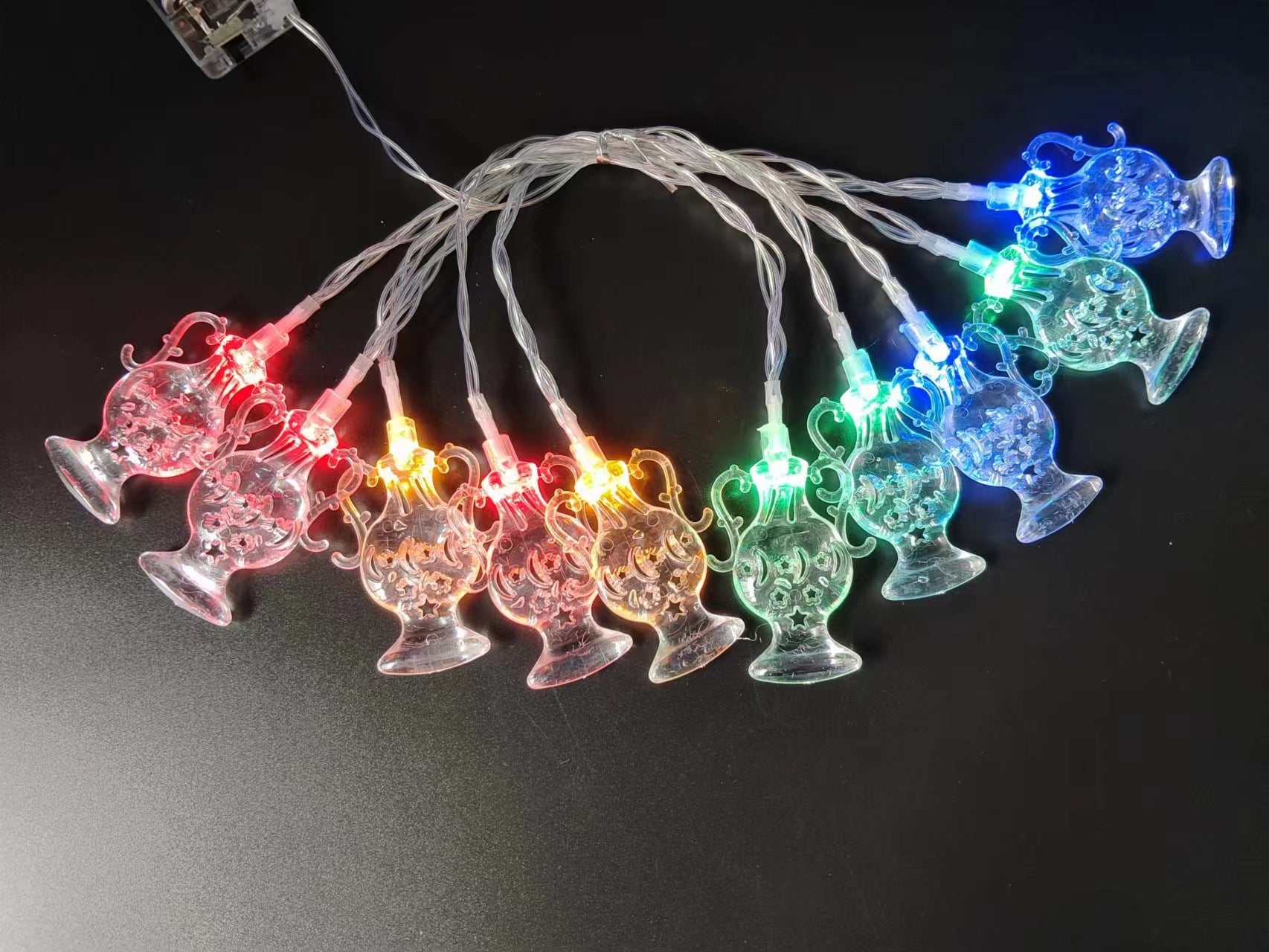 String lights with colorful glass bottle design on a dark background