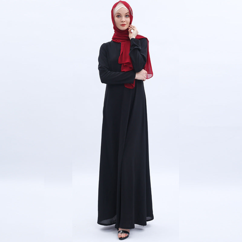Woman wearing a black dress with a red hijab on a white background
