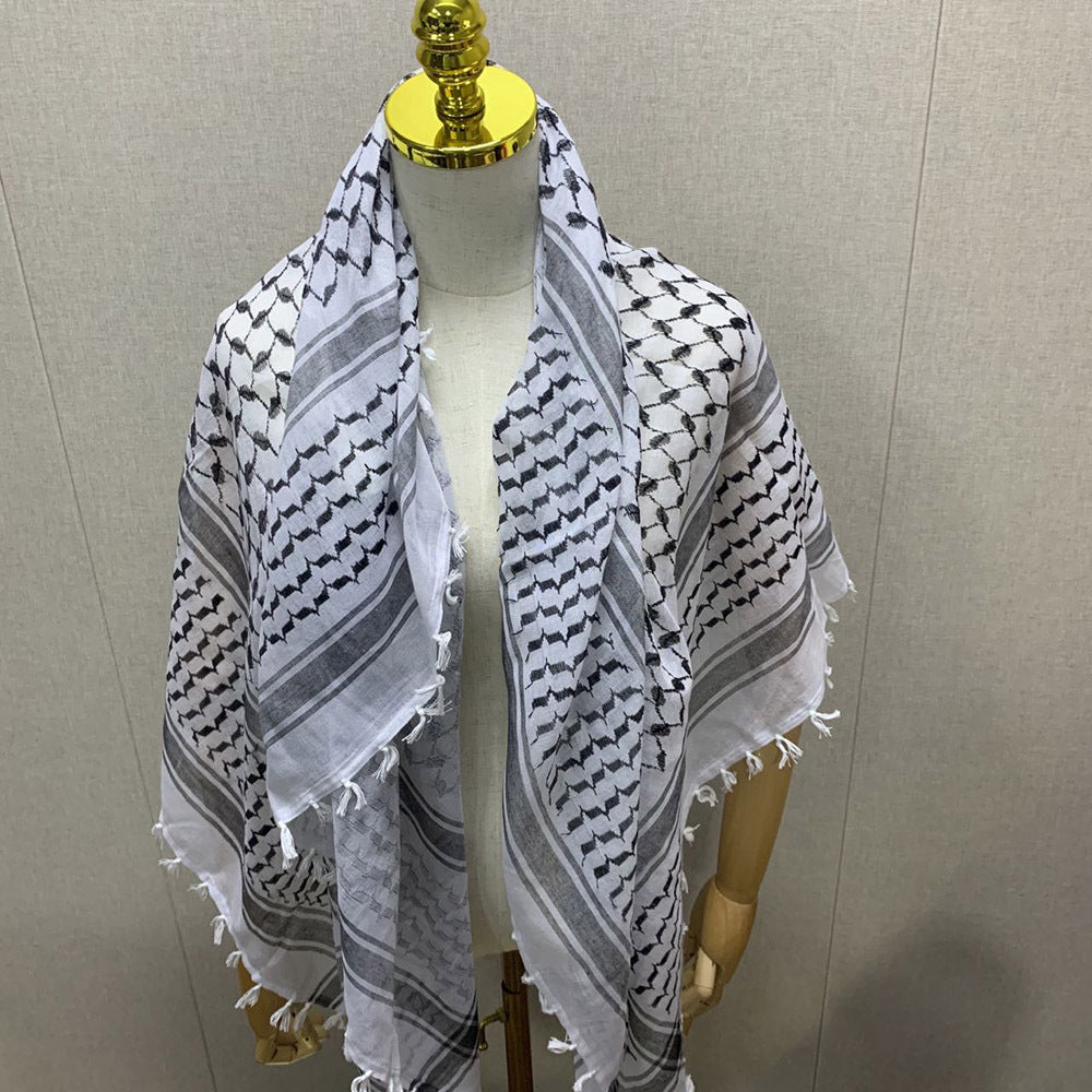 White and black patterned scarf on a mannequin against a plain background