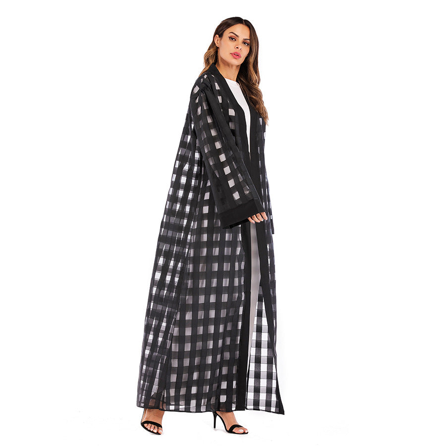 Woman wearing a black and white checkered abaya on a white background