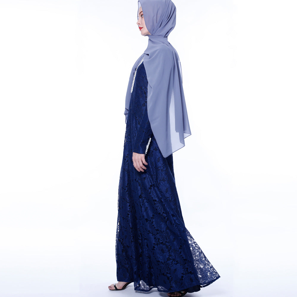 Woman wearing a blue lace dress and light gray hijab on a white background