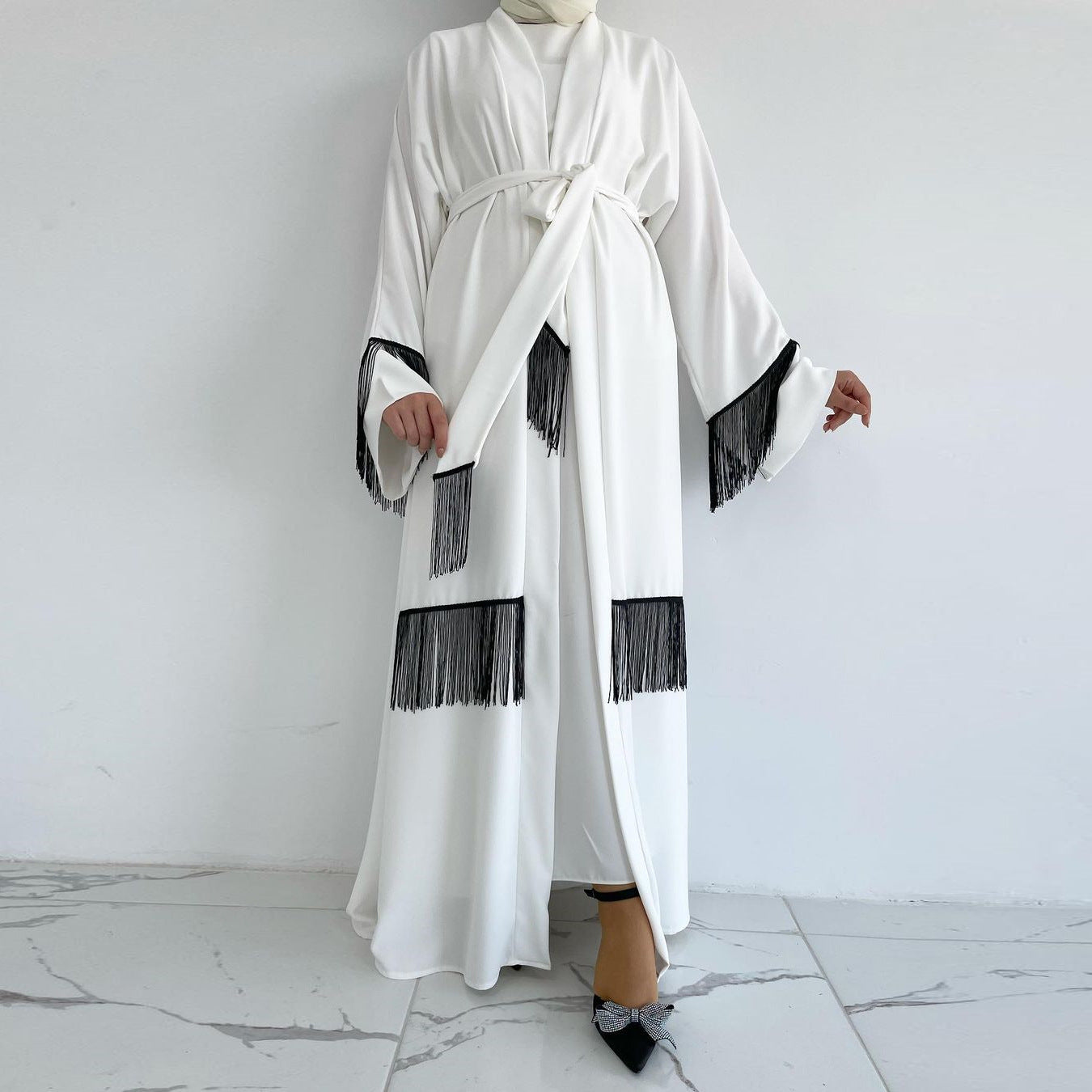 White abaya with black fringes on a white background