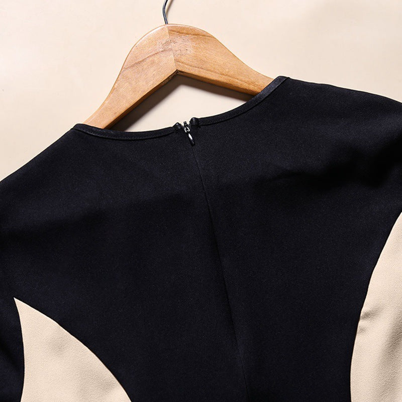 Black and beige long-sleeve top on a wooden hanger against a beige background