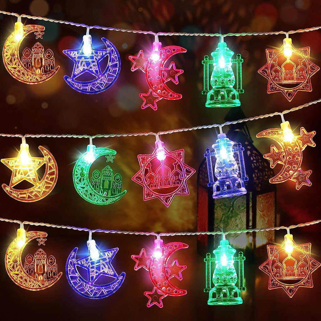 Decorative string lights with moon, star, and building shapes on a dark background.