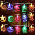 Decorative string lights with moon, star, and building shapes on a dark background.