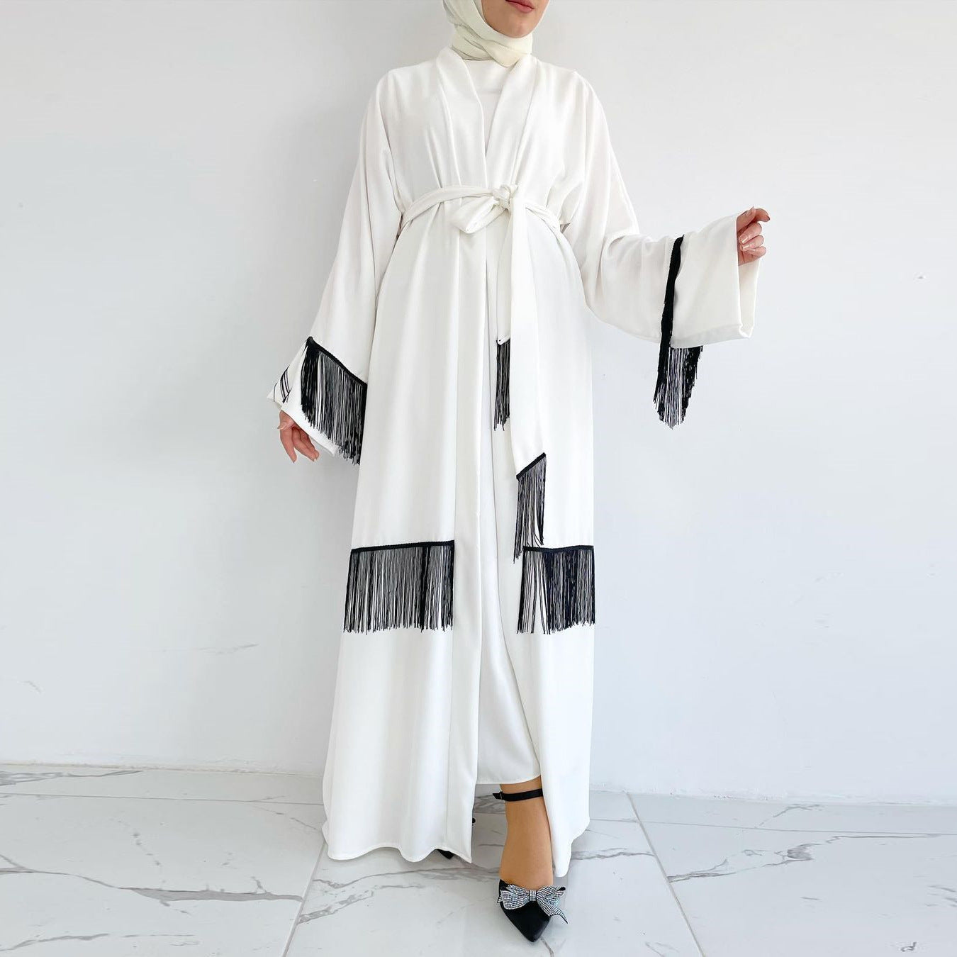 White robe with black fringe details on a white background